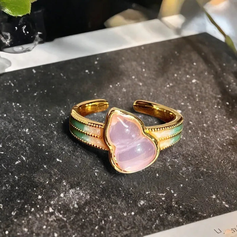 Adjustable copper ring with vintage oil dripping finish showing gourd, flower and bow design with inlaid zircon stones.