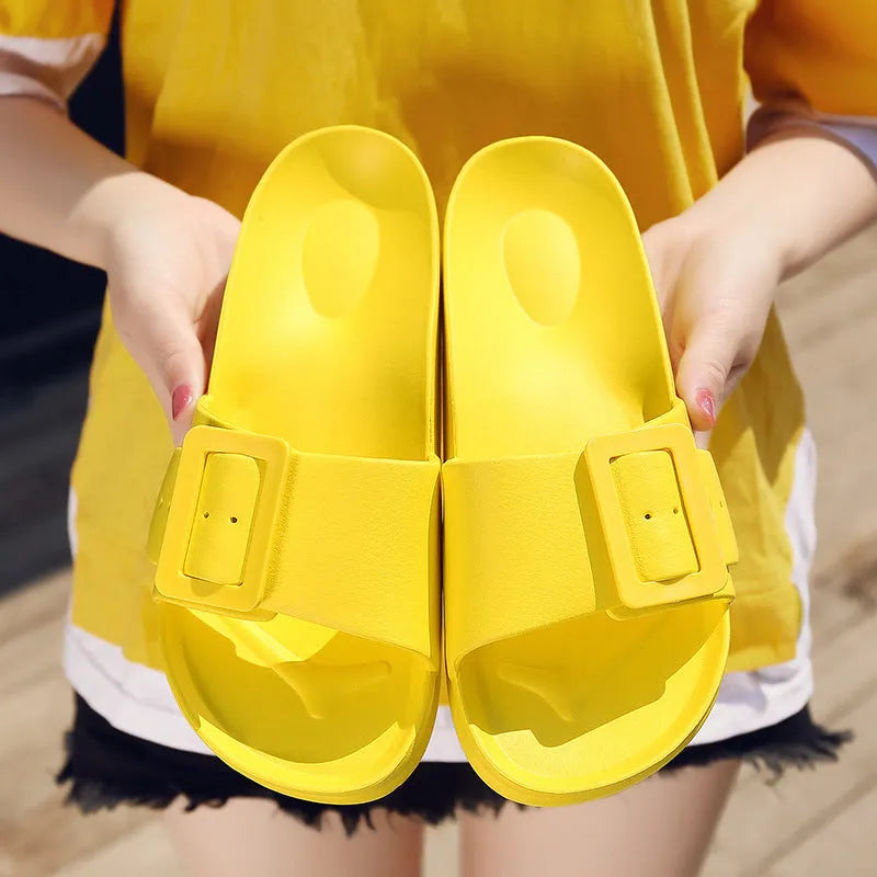 Women's grey-blue EVA flip-flop slippers with a silver buckle fastening on a white background.