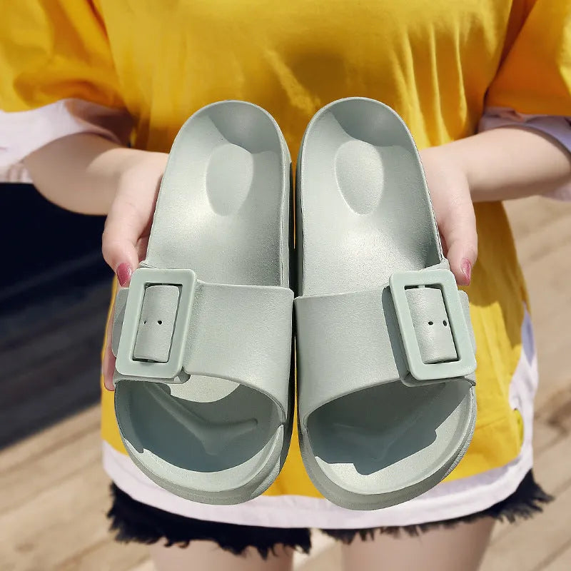 Women's grey-blue EVA flip-flop slippers with a silver buckle fastening on a white background.