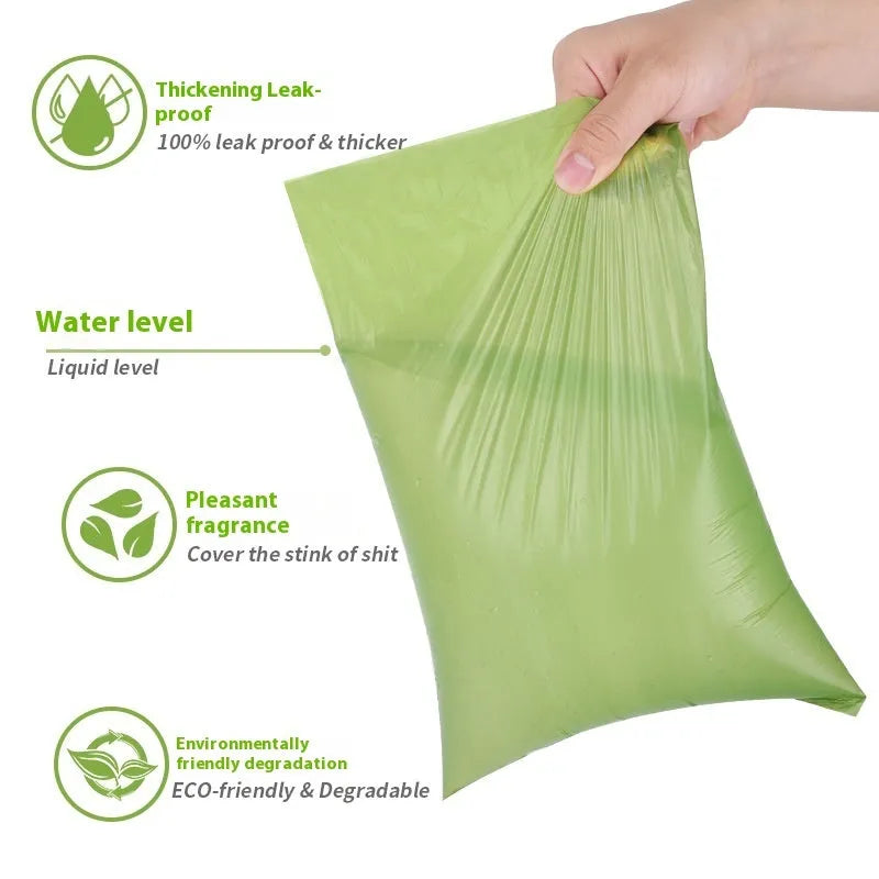 Roll of EPI degradable green dog poo bags next to a time-capsule-style dispenser on a grass background.