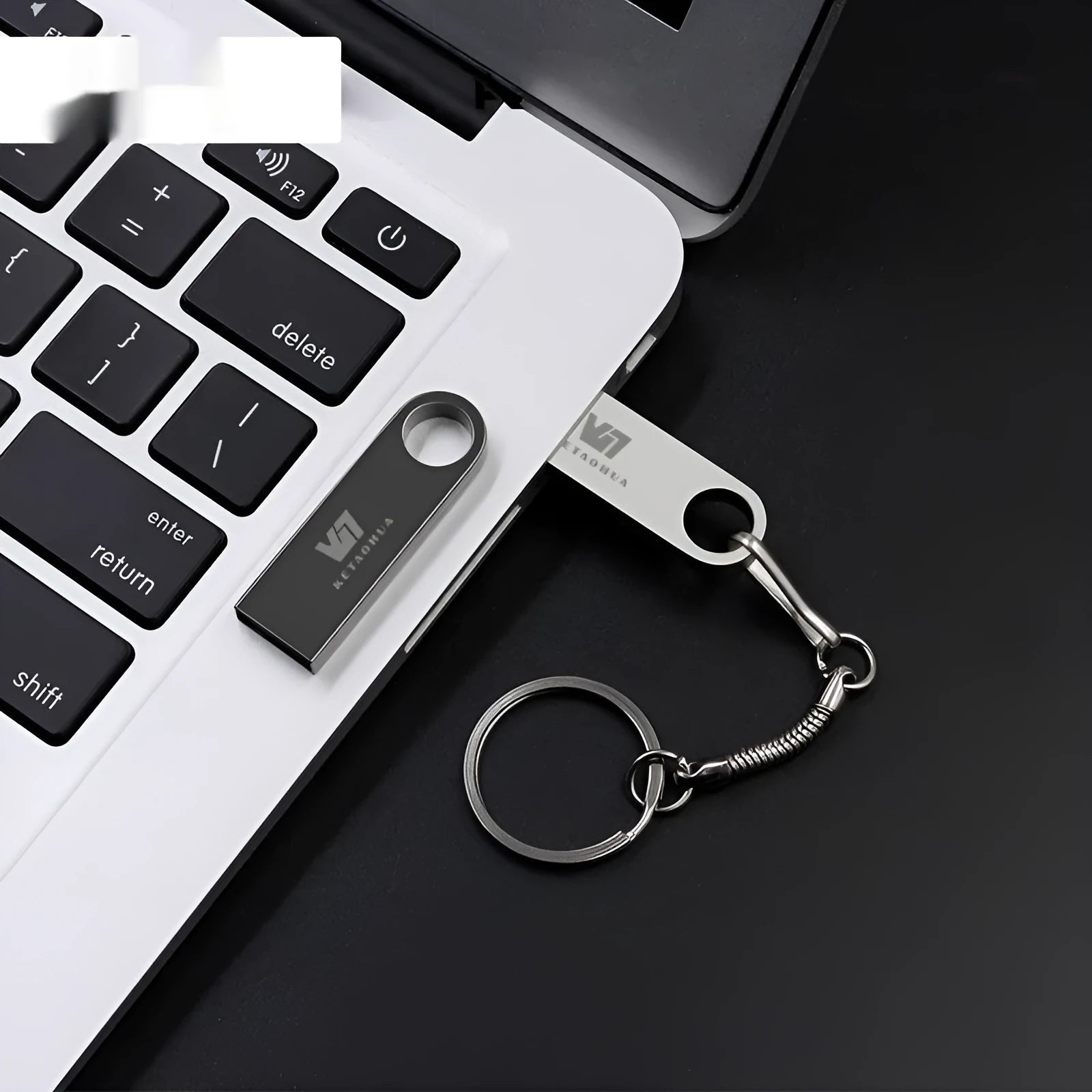 Silver metal car-shaped USB flash drive on a white background showing front and side details.