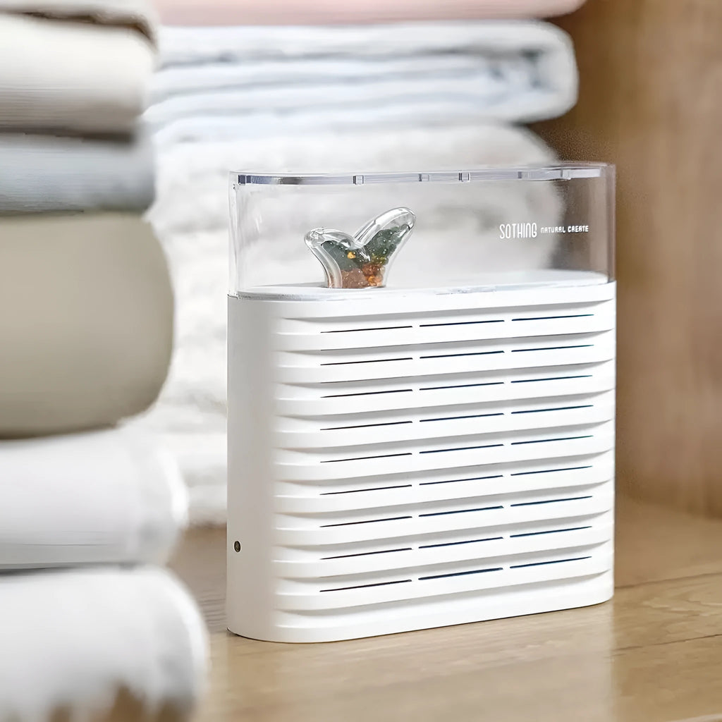 White reusable cabinet dehumidifier box with transparent leaf-design top showing colour-changing silica gel beads inside.