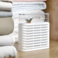 White reusable cabinet dehumidifier box with transparent leaf-design top showing colour-changing silica gel beads inside.