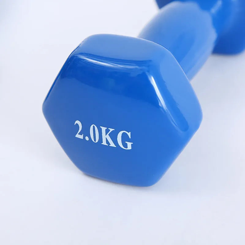 A set of bright colourful plastic dumbbells in different sizes on a light floor.