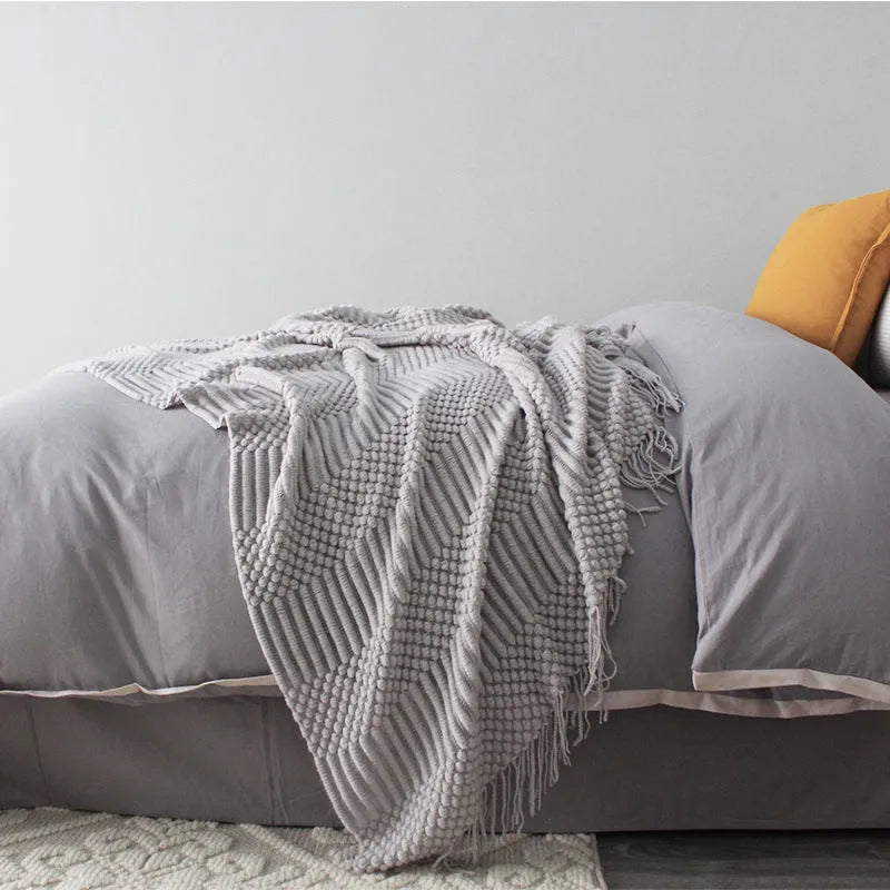 Small light grey polyester nap blanket folded, showing its size of 127 by 170 centimetres.