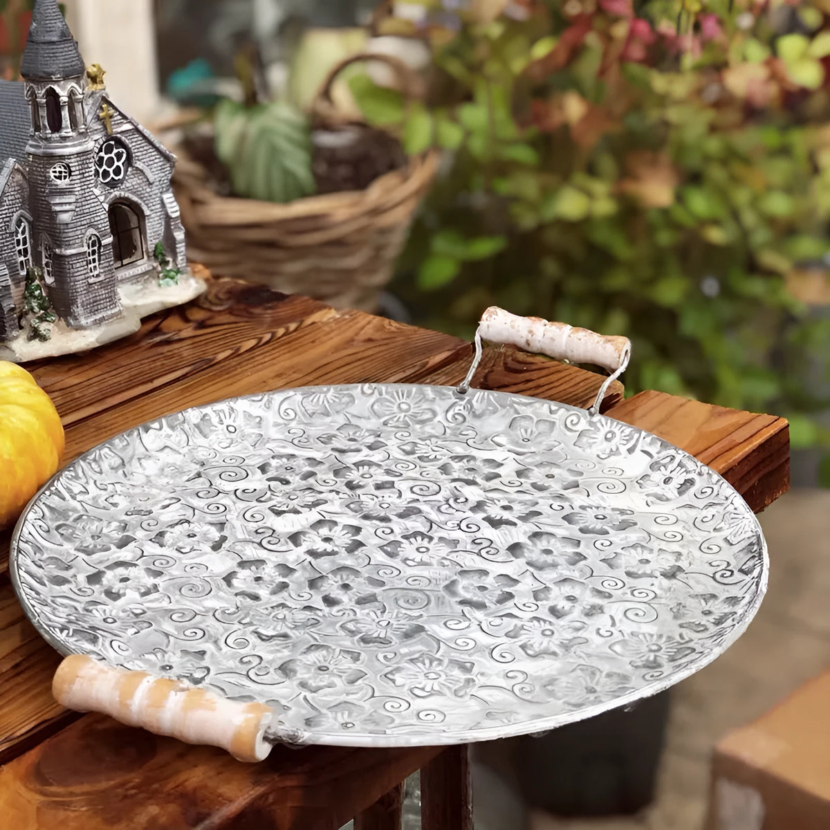 Round wrought iron storage trays in two sizes on a wooden surface