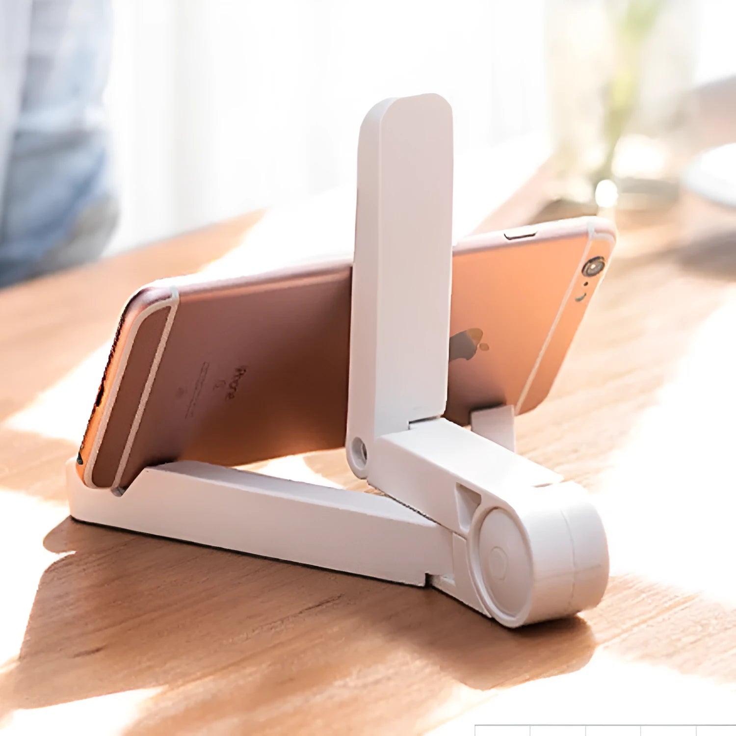 Black foldable tablet holder displaying a smartphone in landscape mode on a desk.