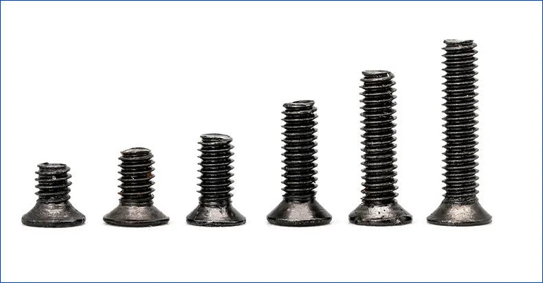 Black laptop machine screws with cross slot countersunk heads, 1.4mm diameter, in a box.
