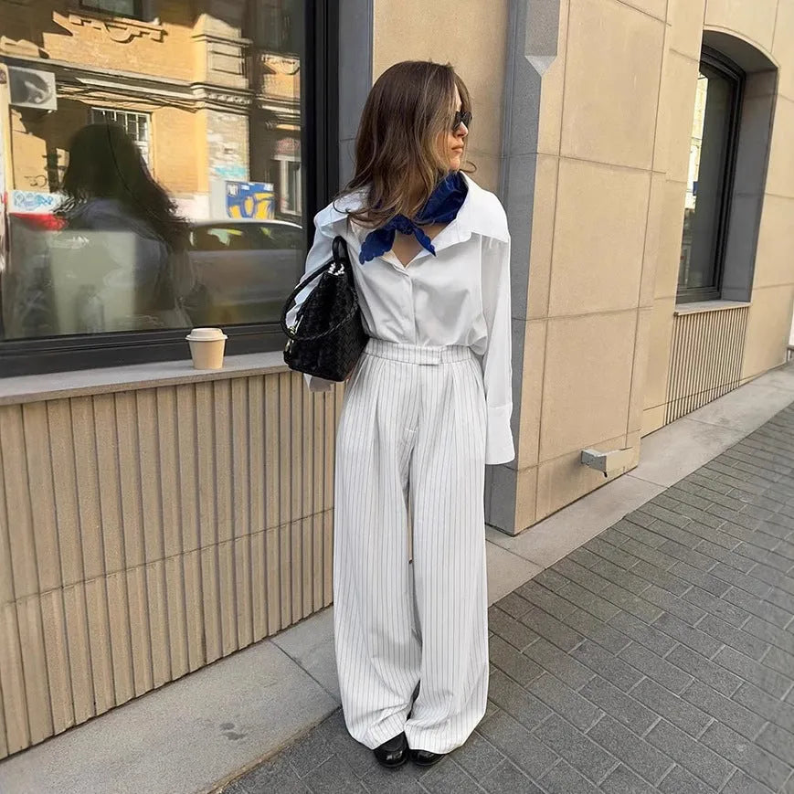 White striped wide-leg women's trousers with front zip fastening on hanger