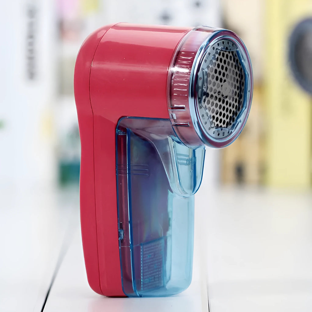 Compact white portable electric lint remover for clothing on a grey background.