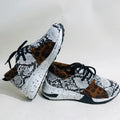 Women's black casual sneakers with a suede upper and a low wedge heel on a plastic sole.