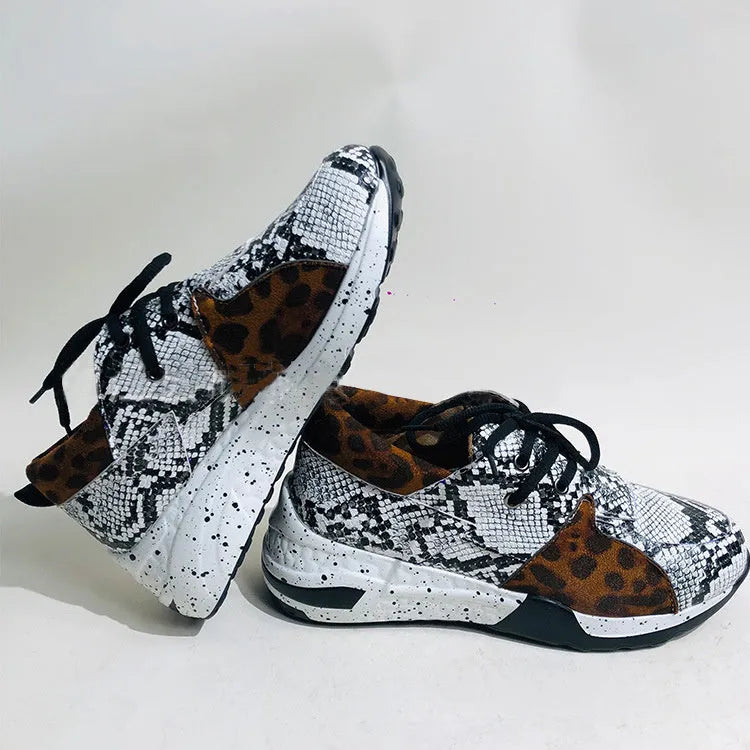 Women's black casual sneakers with a suede upper and a low wedge heel on a plastic sole.