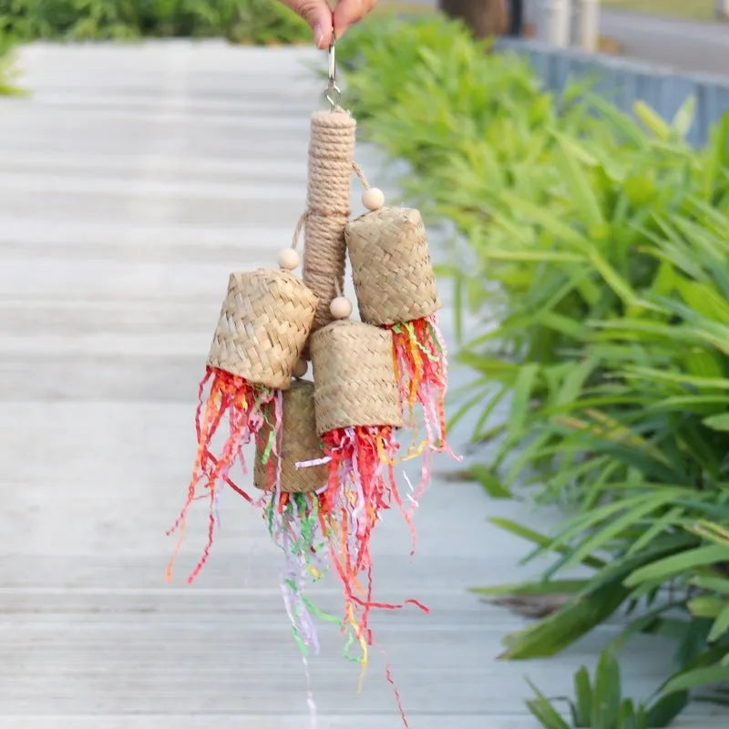Parrot toy with wood pieces, sisal rope and colourful shredded paper strips hanging for bird enrichment
