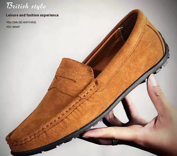 Men's brown suede casual loafers with a round toe, flat rubber sole, and visible stitching on a white background.