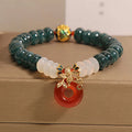 Blue water jade and red agate beaded bracelet with a peace symbol buckle clasp.