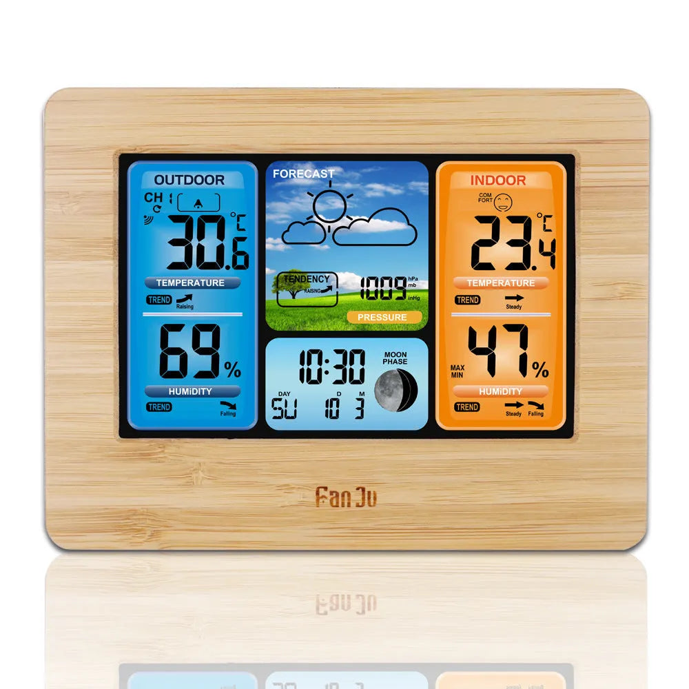 Black rectangular LCD digital weather station displaying temperature, humidity, pressure, and time on a desk.