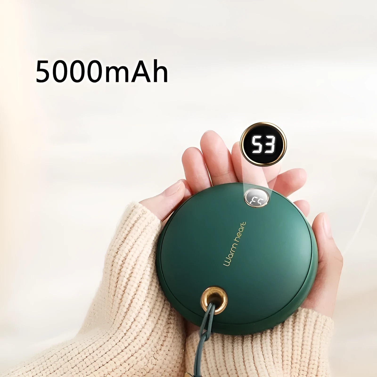 Green hand warmer power bank with digital display showing battery level, next to a charging cable.