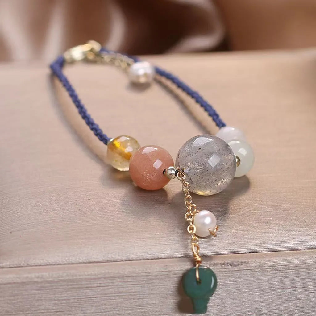 Hand-woven women's bracelet with a crystal buckle and sequins on blue string.