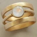 Geometric titanium steel ring with hollow micro-inlaid white chalcedony stones and gold electroplated finish