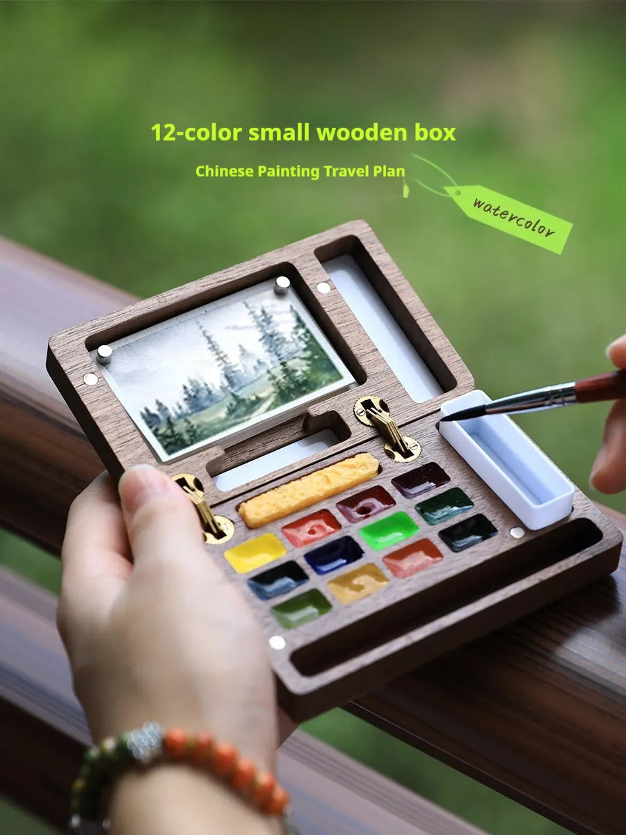 Mini wooden watercolour paint box with walnut finish, showing closed lid.
