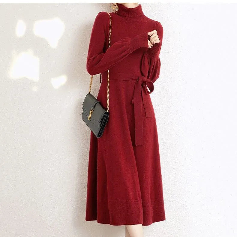 A rose red knitted turtleneck dress with long sleeves, an elastic waist, and a loose mid-length skirt.
