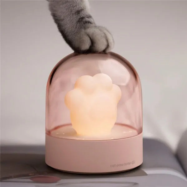 Grey and pink cat paw shaped USB rechargeable night light with music box function on desktop