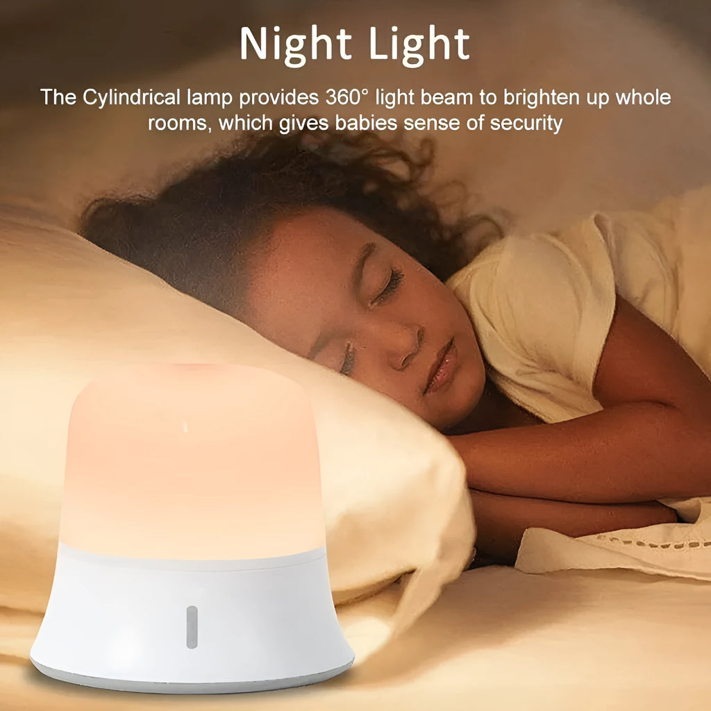 White baby night lamp with touch controls for dimming and colour change on a bedside table.
