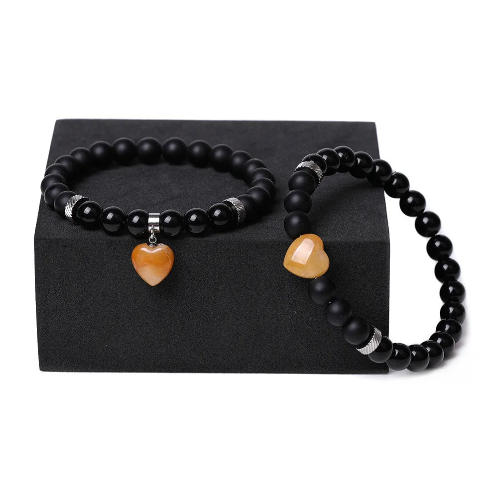Two matching natural stone heart bracelets with geometric shape and polished finish.