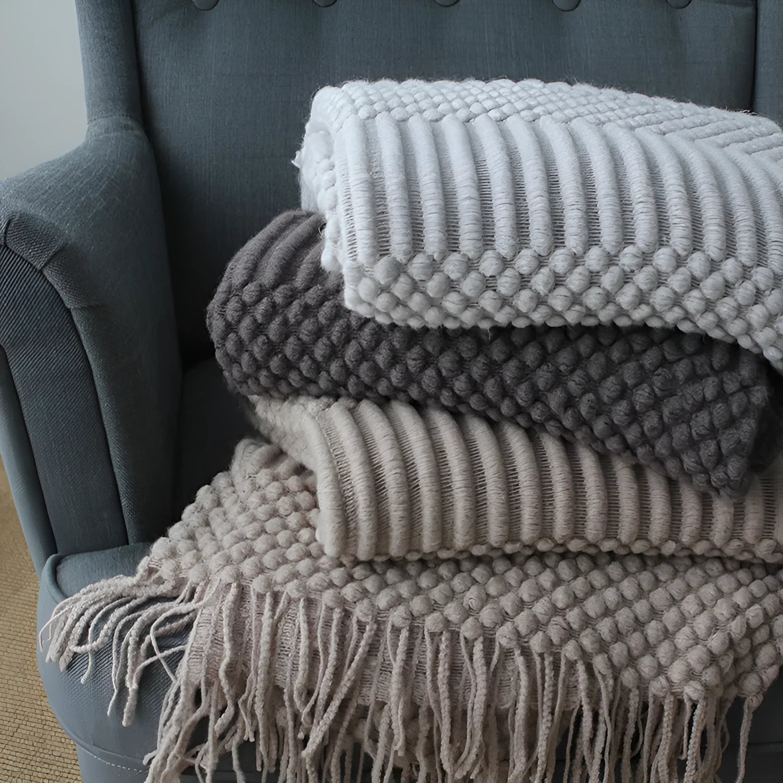 Small light grey polyester nap blanket folded, showing its size of 127 by 170 centimetres.
