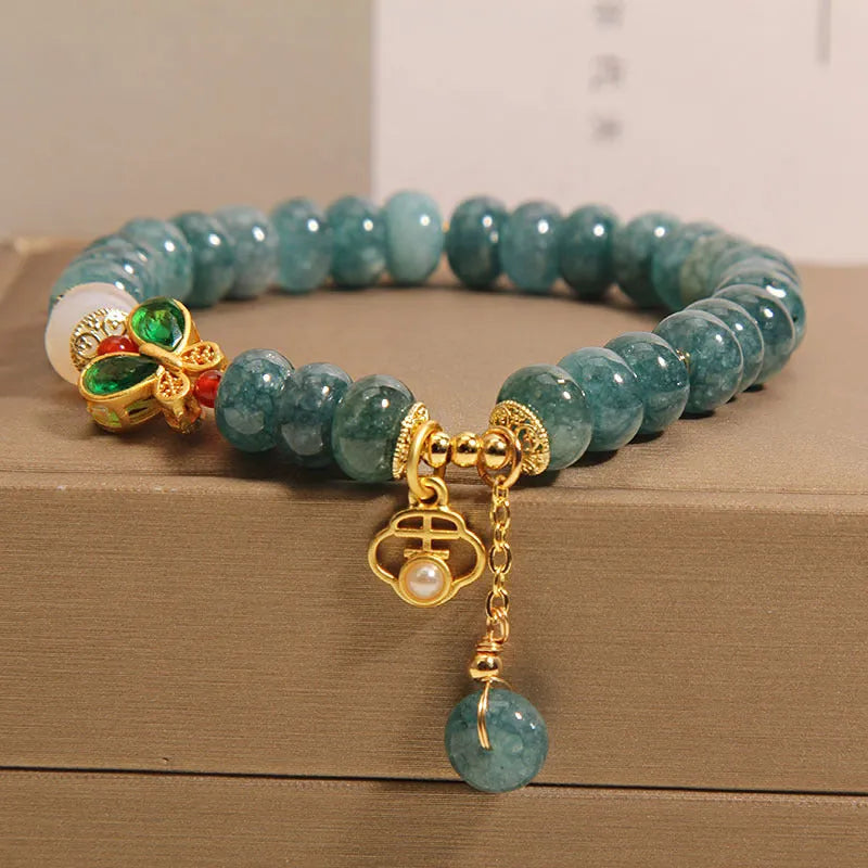 Blue jade abacus bead bracelet with alloy inlay and rhinestone decoration showing butterfly and white agate elements