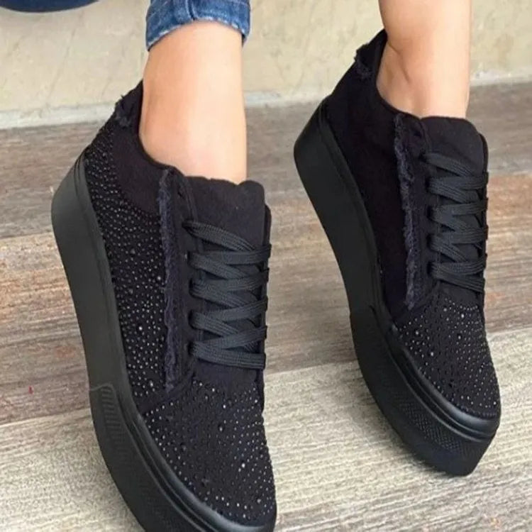 Women's plus size black casual pump with rhinestone decorations and a flat rubber sole.