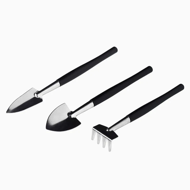 Black plastic and metal 16-piece mini gardening tool set for succulents and bonsai, laid out with a cushion.