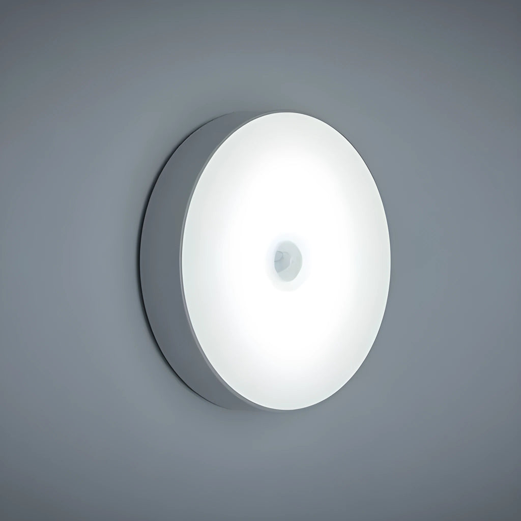 USB rechargeable motion sensor night light in beige or white, 86mm diameter, with adhesive tape