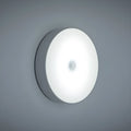 USB rechargeable motion sensor night light in beige or white, 86mm diameter, with adhesive tape