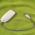 Black flexible gooseneck USB LED lamp bent over a book.