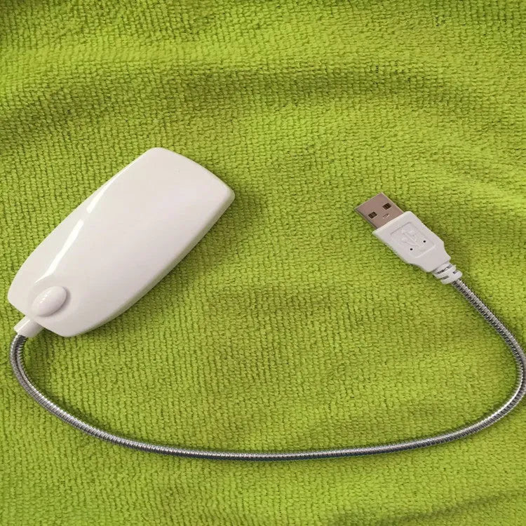 Black flexible gooseneck USB LED lamp bent over a book.