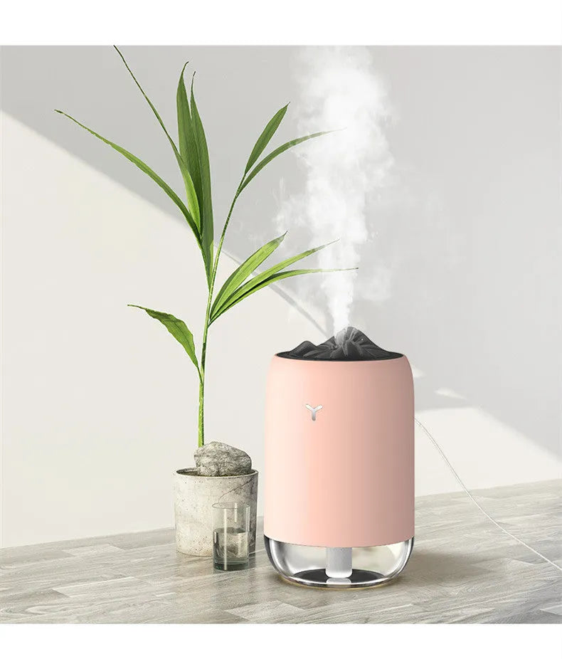 White columnar Magic Flame ultrasonic humidifier with USB cable on a wooden desk.