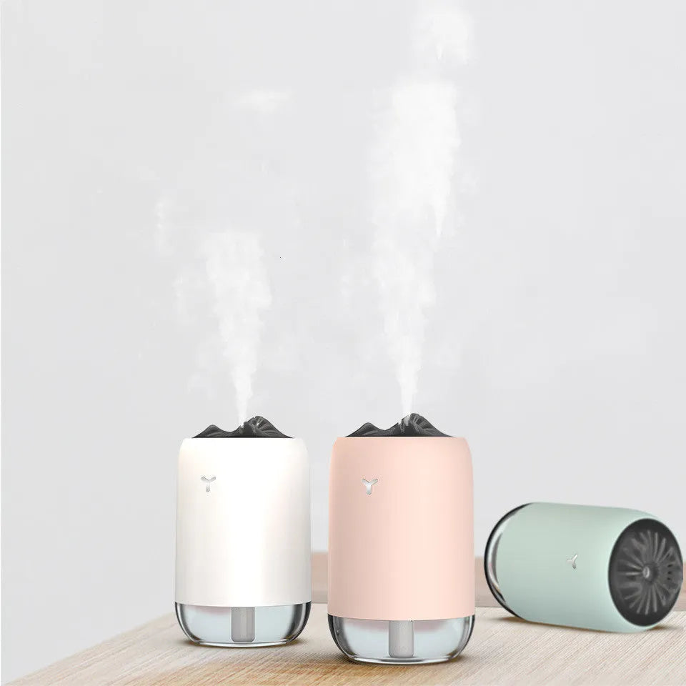White columnar Magic Flame ultrasonic humidifier with USB cable on a wooden desk.