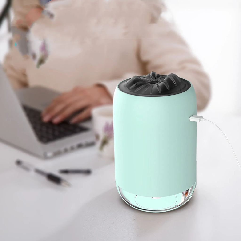 White columnar Magic Flame ultrasonic humidifier with USB cable on a wooden desk.