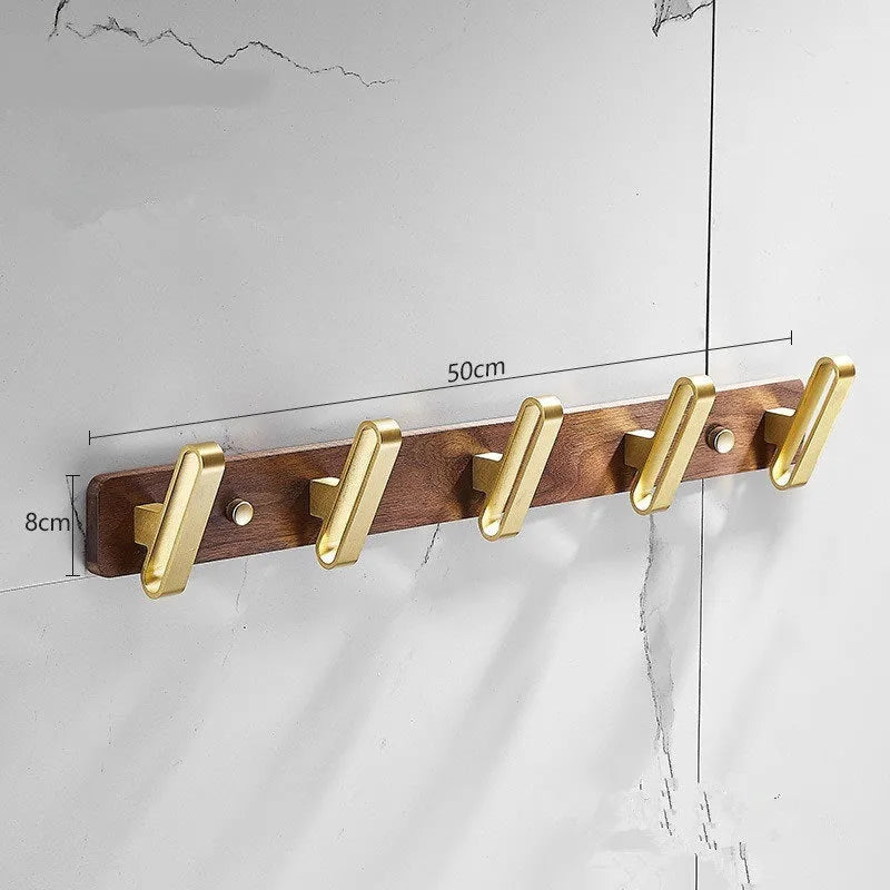Black walnut wood hooks mounted on a perforated aluminium plate for bathroom towel hanging.