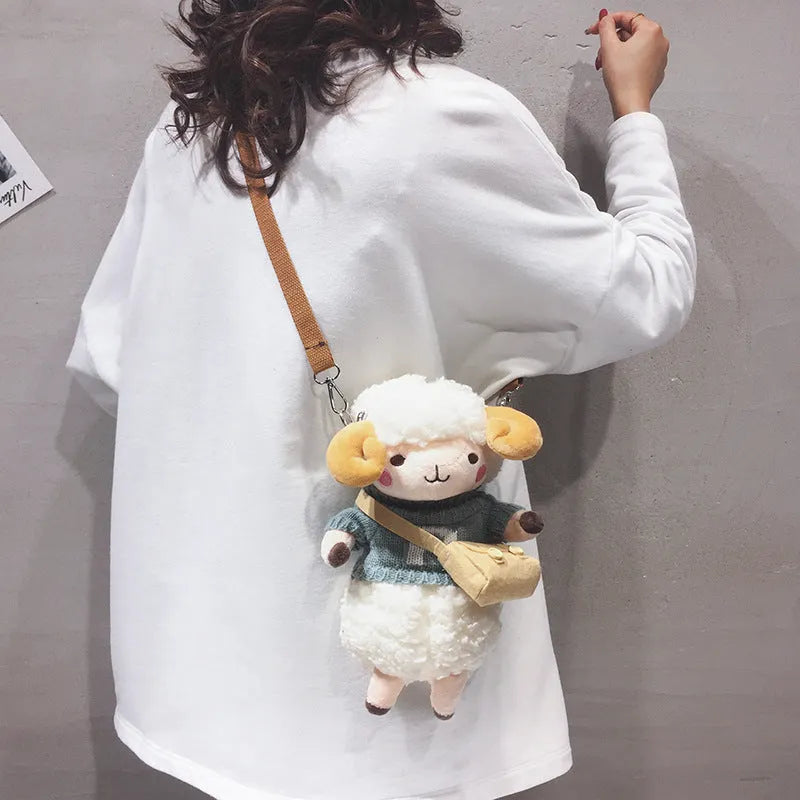 Small blue plush crossbody bag with square design, zip opening, and lamb pattern