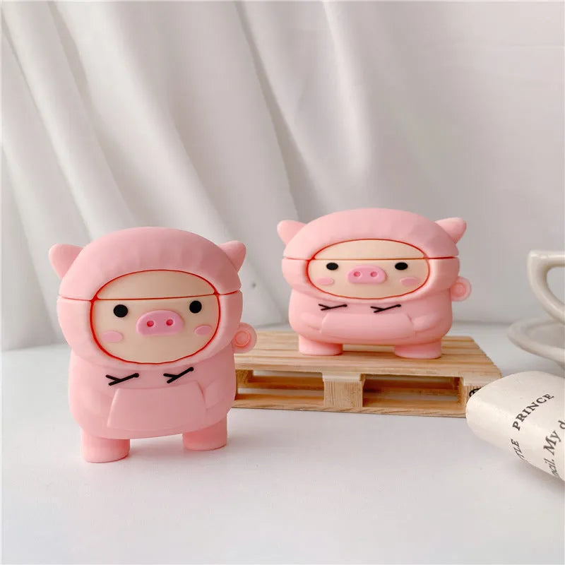 Pink silicone flip case with a cartoon pig design for AirPods and AirPods Pro, shown with a keychain hook.