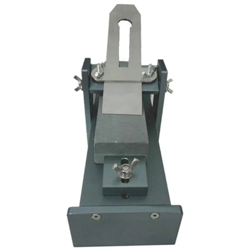 Aluminium fixed angle sharpening tool for woodworking chisels and planers on a workbench.