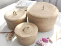Japanese style fabric storage basket with a fitted lid in three sizes on a table.