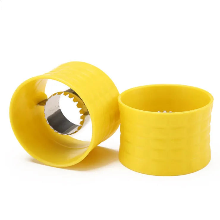 Yellow manual corn grinder thresher with corn kernel shaped grip on a kitchen worktop.