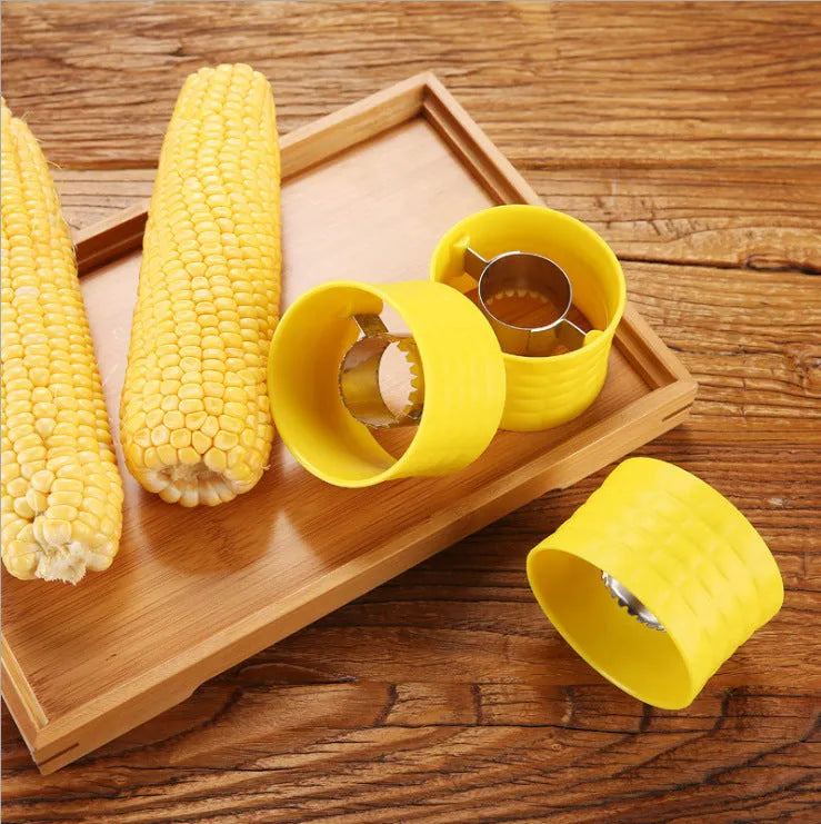 Yellow manual corn grinder thresher with corn kernel shaped grip on a kitchen worktop.