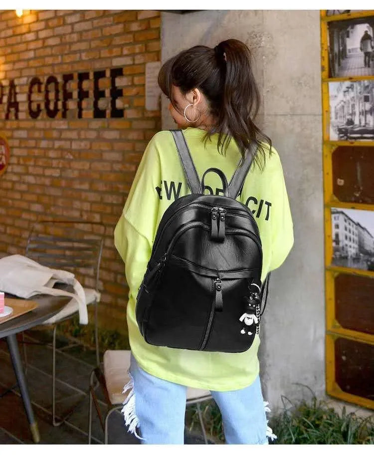 Medium black backpack in soft surface PU leather with double shoulder straps showing zipper closure