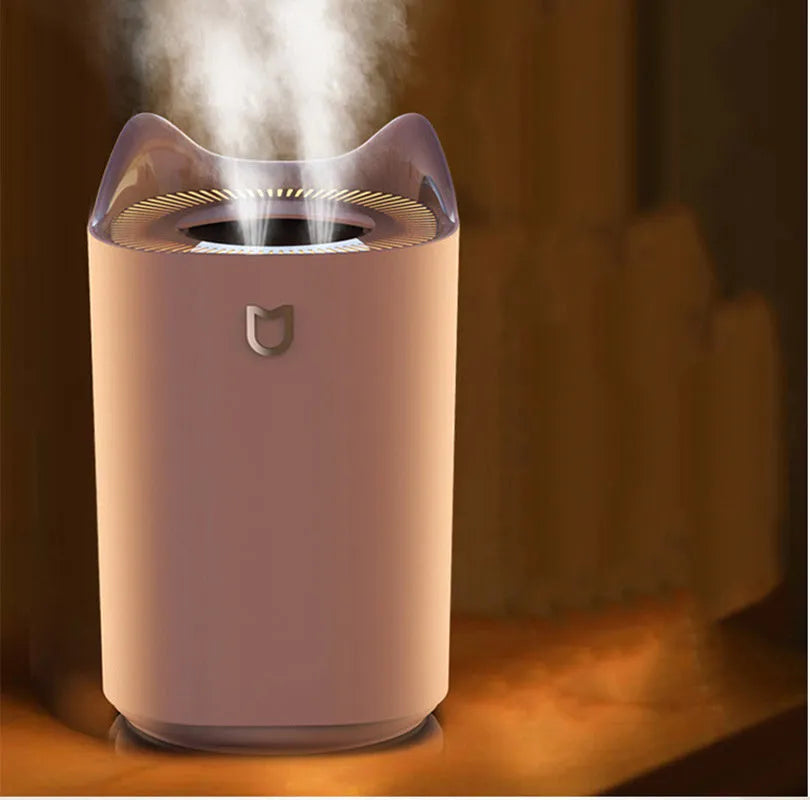 Double spray humidifier with USB cable and three mist outlets in coral pink or white for bedroom use.
