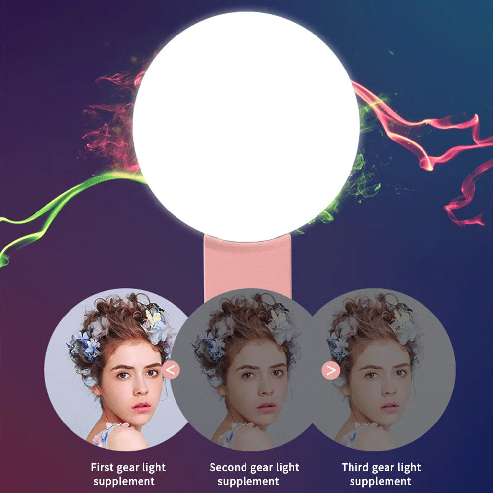 Small round white LED fill light clipped onto a mobile phone for taking selfies.