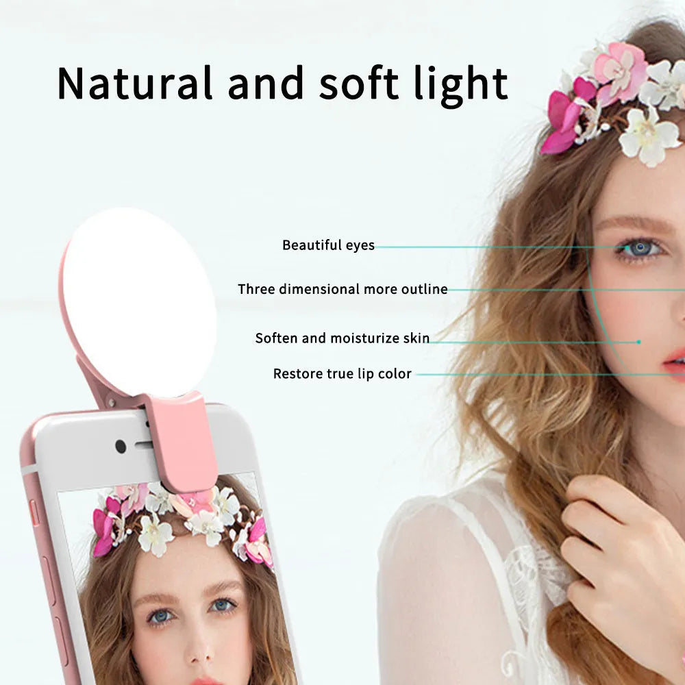 Small round white LED fill light clipped onto a mobile phone for taking selfies.